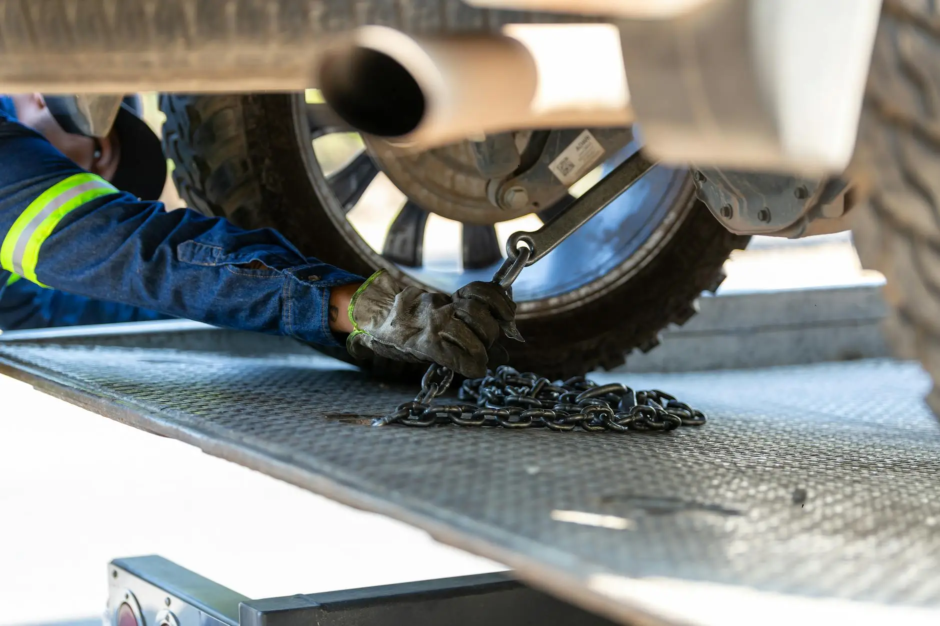 A professional tow truck operator preparing a flatbed tow truck for a vehicle transport on a clear day in Oak Creek.