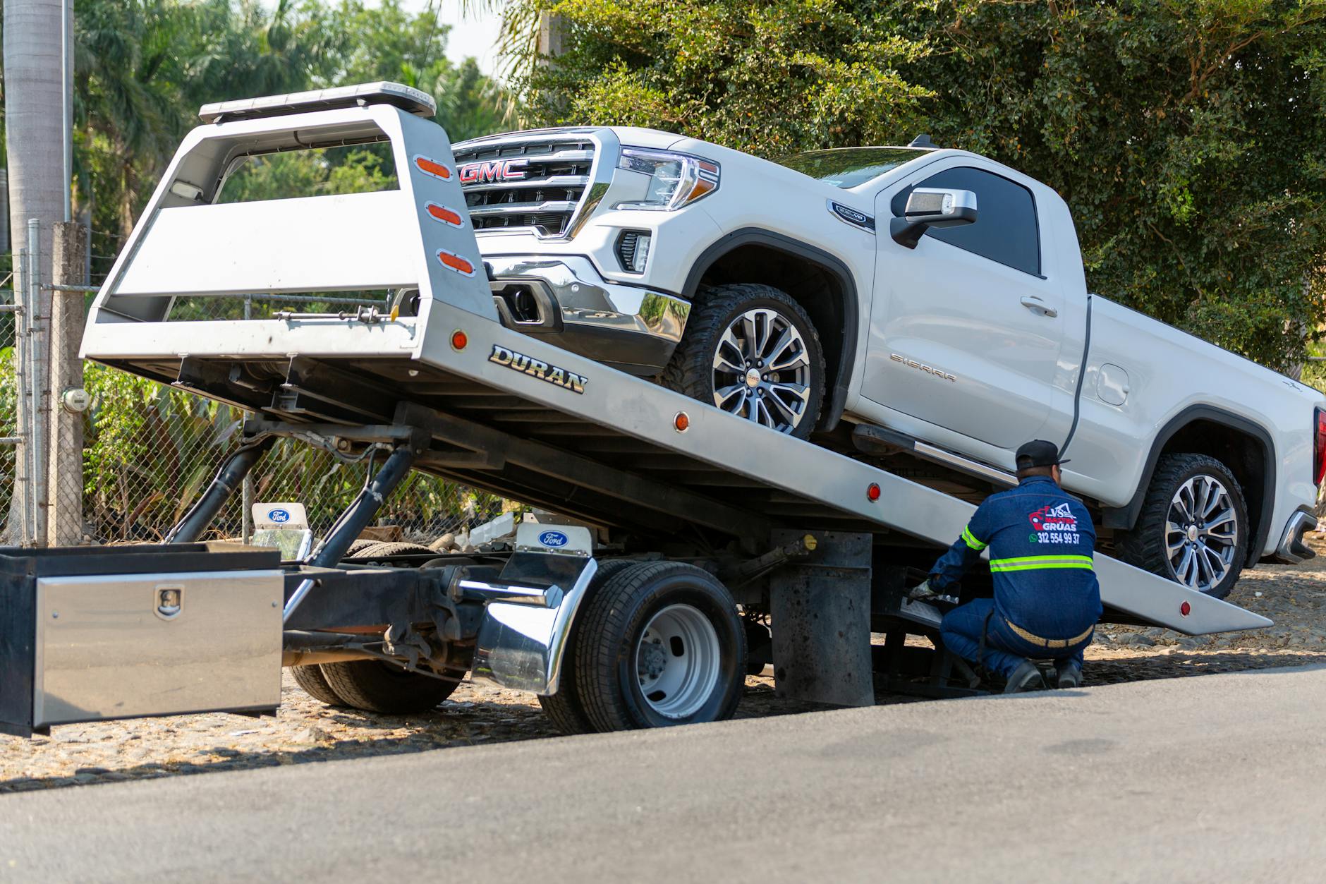 A clean, modern flatbed tow truck ready for dispatch in a Brookfield commercial district.